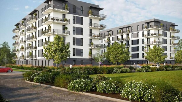 A modern multi-story residential building with balconies, a landscaped garden, and a clear sky. - 1-bed Top Floor Apartment in Warszawa (Warsaw)