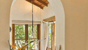 A cozy room with a hanging chair, a window with curtains, and a view of greenery outside. - The Jungle Loft - Galle (Galle)