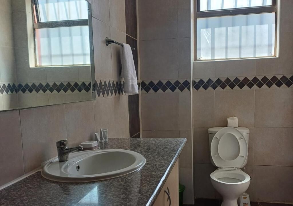 A bathroom with a sink, mirror, and toilet.
