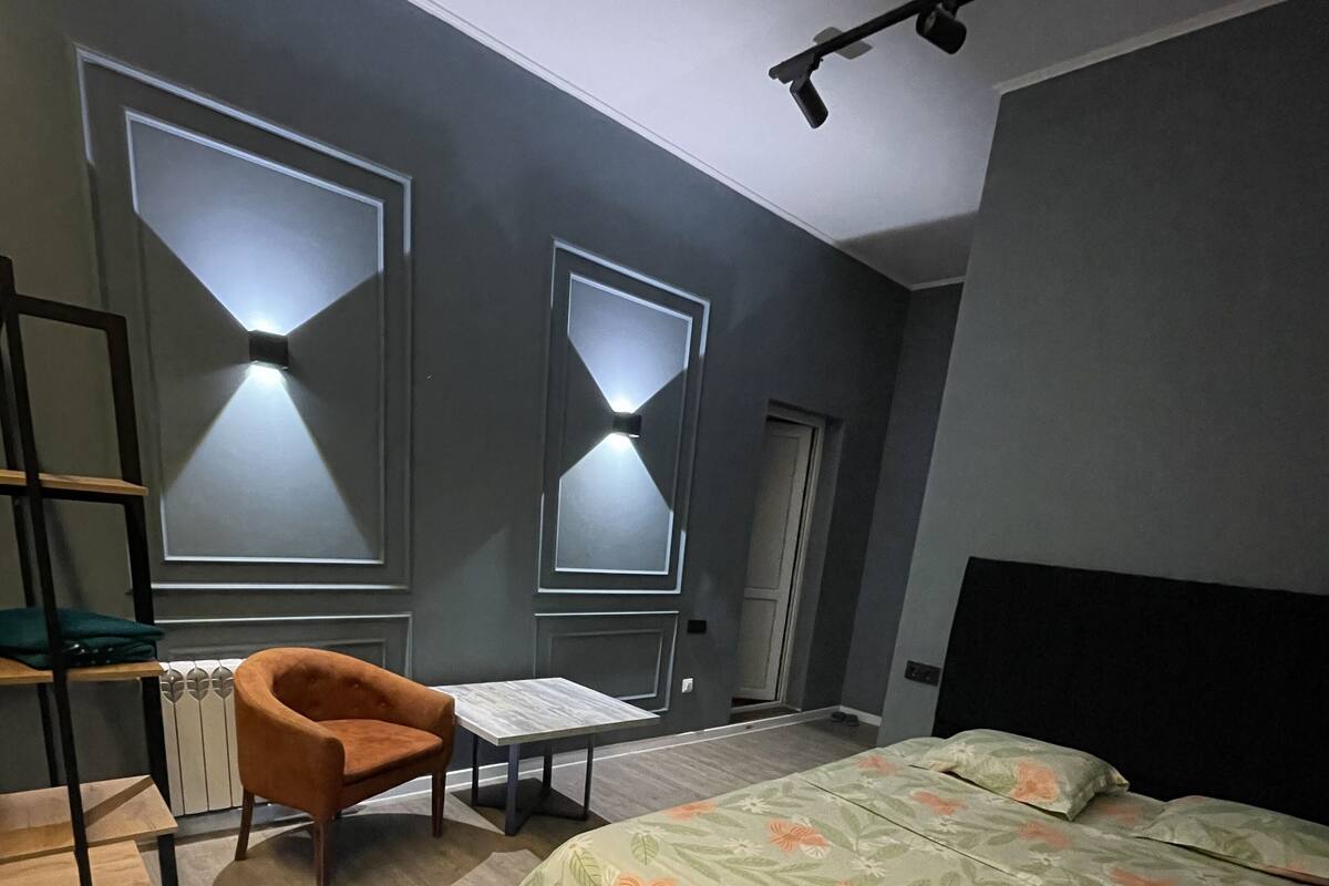 Une chambre à coucher avec un lit, une chaise, un bureau et un radiateur.