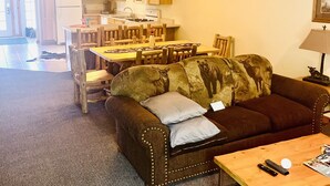 A cozy living room with a sofa, a wooden coffee table, and a dining area with a table and chairs.