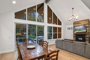 A spacious living area with a large wooden dining table, a built-in fireplace, and a cozy seating area.