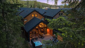 Une cabane dotée d’une grande terrasse, d’un bain à remous et d’un coin repas.