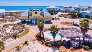 Une propriété située en bord de mer, comprenant une grande maison, une piscine et une vue sur la plage.