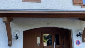 A building entrance with a wooden door, a small window above the door, and a number '371' above the door. - Charming Bright Spacious Village Walk to lift Hike (Praz Sur Arly)