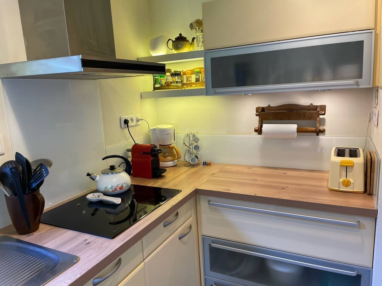 Una cocina compacta con estufa, cafetera y tostadora.