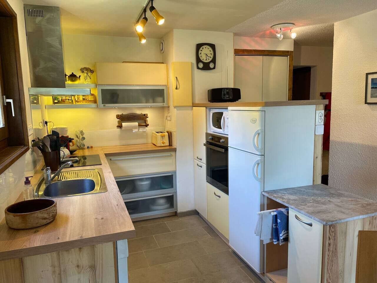 A compact kitchen with a sink, toaster, microwave, and oven.