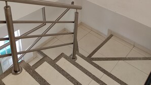Una escalera con barandillas metálicas y baldosas de suelo con diseños.