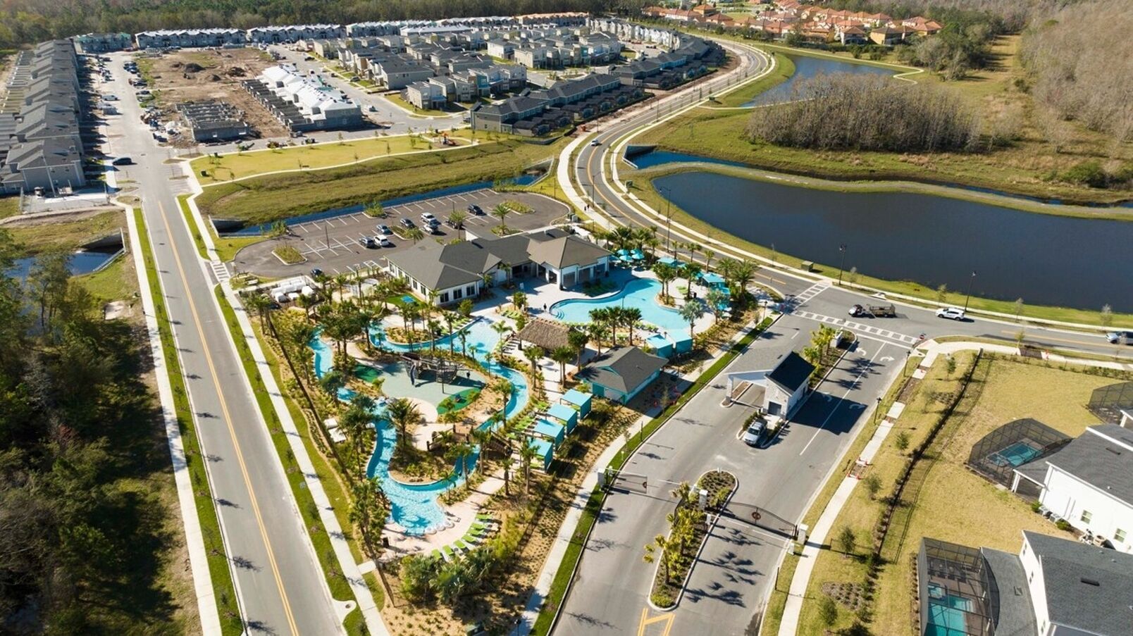Luchtbeeld van een resort met een zwembad, wegen en een meer.