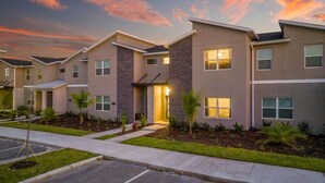 A modern apartment complex with multiple units, each featuring a balcony and a small garden area. - Amazing Disney resort style & FREE Waterpark 2481 (Kissimmee)