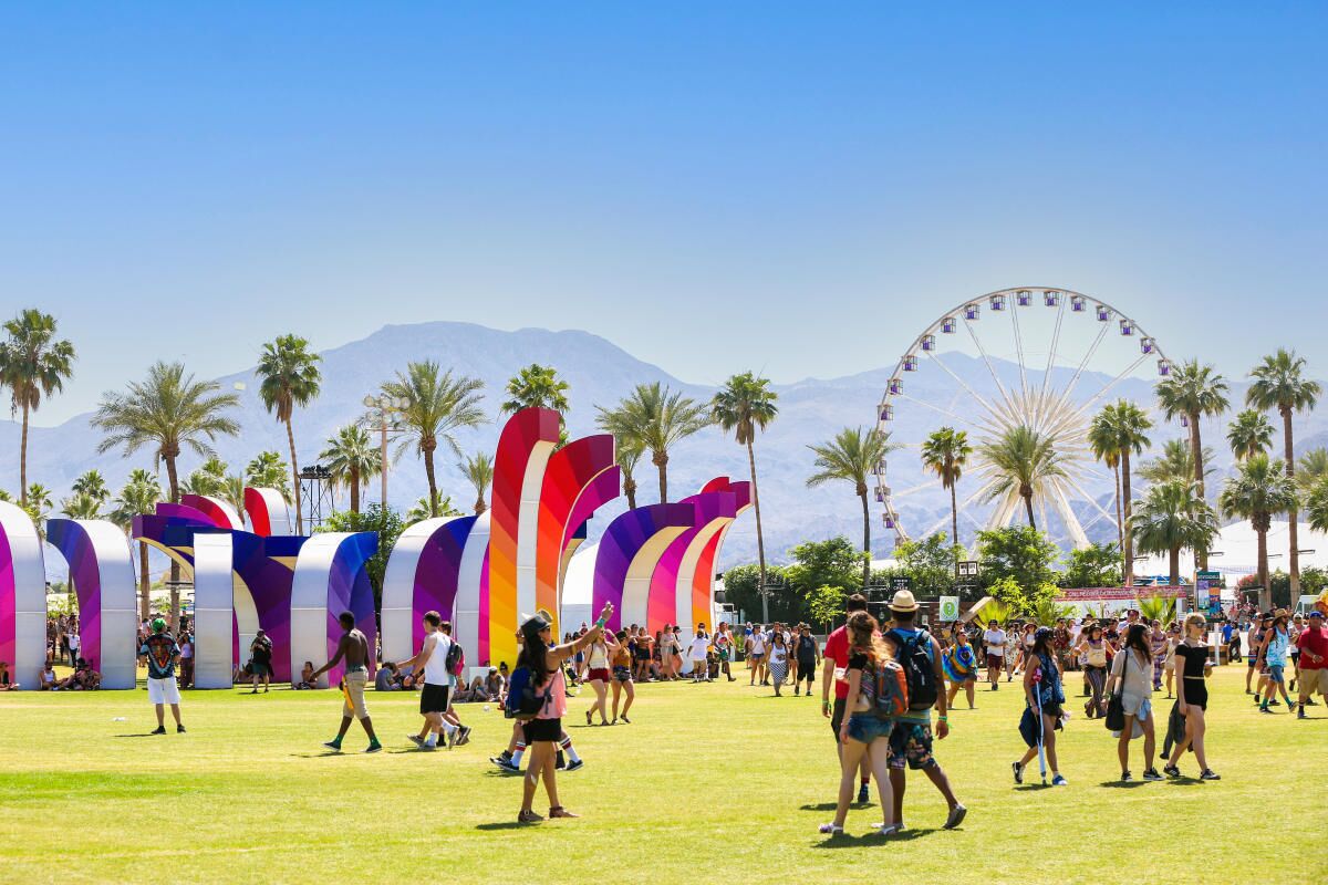 A festival with colorful arches and a Ferris wheel in the background.
