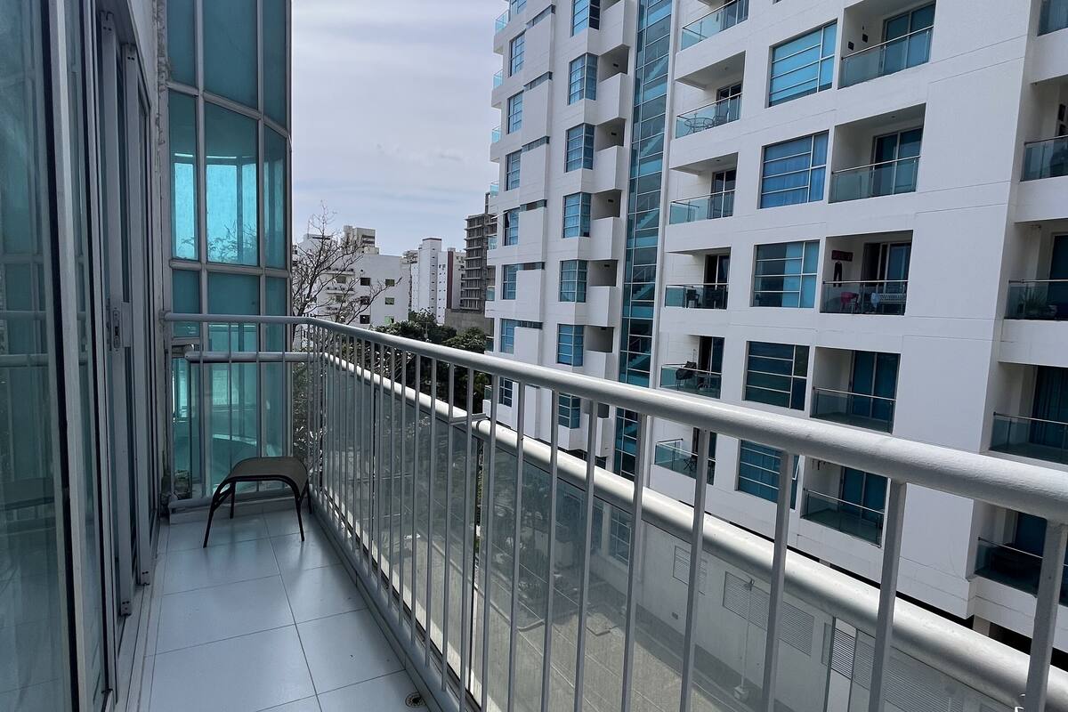 Ein modernes Gebäude mit Balkon, großen Fenstern und einem Metallgeländer.