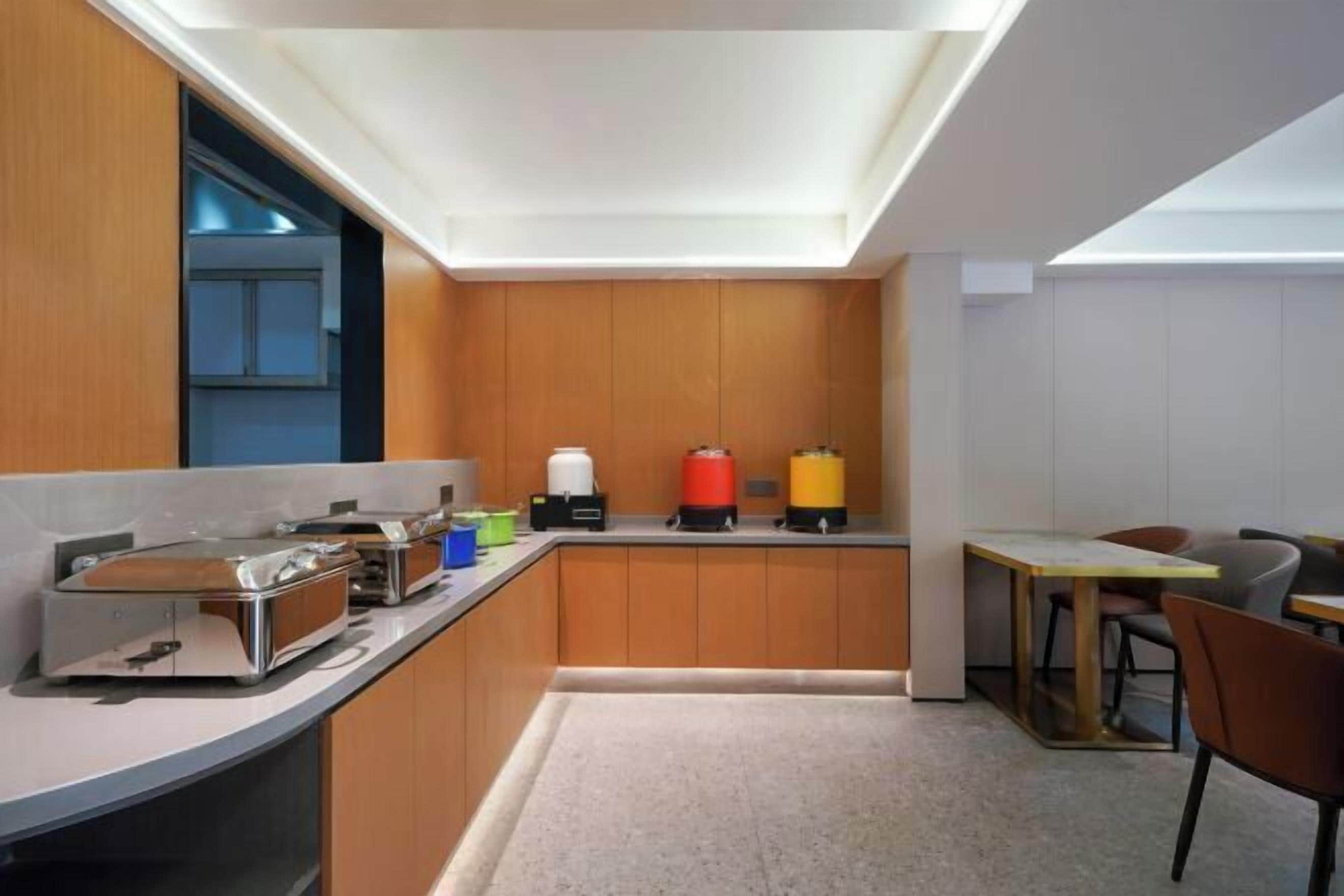 A compact kitchen with built-in appliances, a small dining area, and a visible window.