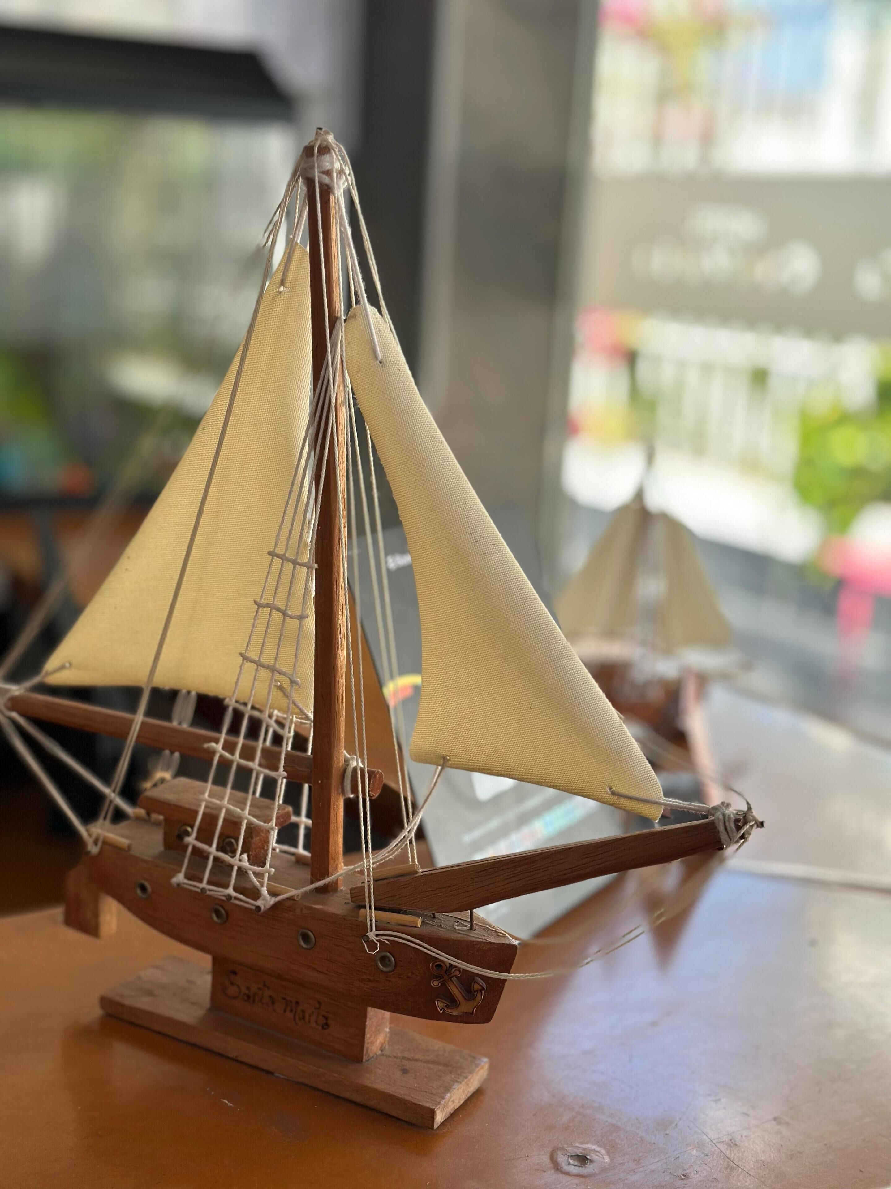 A model sailboat on a wooden base with the inscription "Santa Maria."
