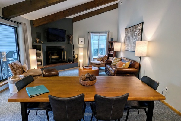Living room with dining table, wood fireplace, and balcony w/ propane BBQ grill