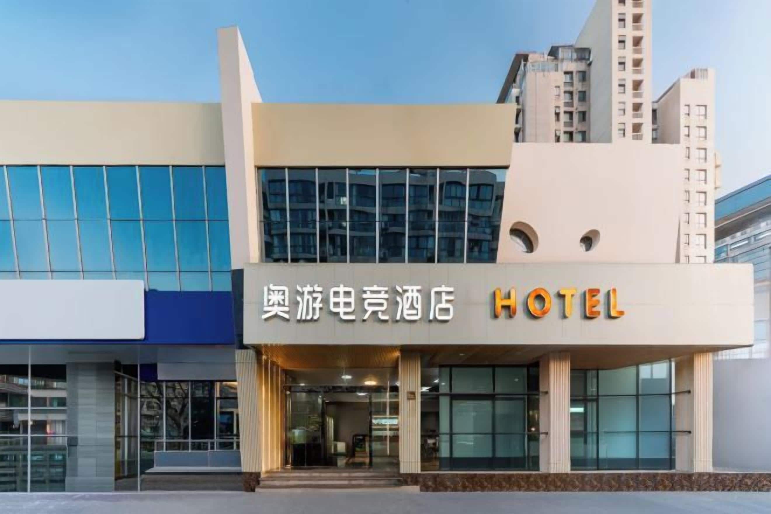 A hotel with a modern facade, large windows, and a prominent sign indicating its name.