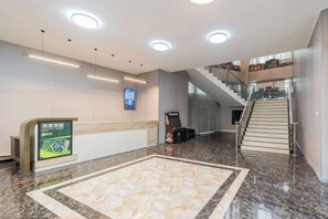 A hotel lobby with a reception desk, a digital screen, a marble floor, and a staircase. - Aoyou Esports Hotel (Shanghai Lujiazui) (Shanghai)
