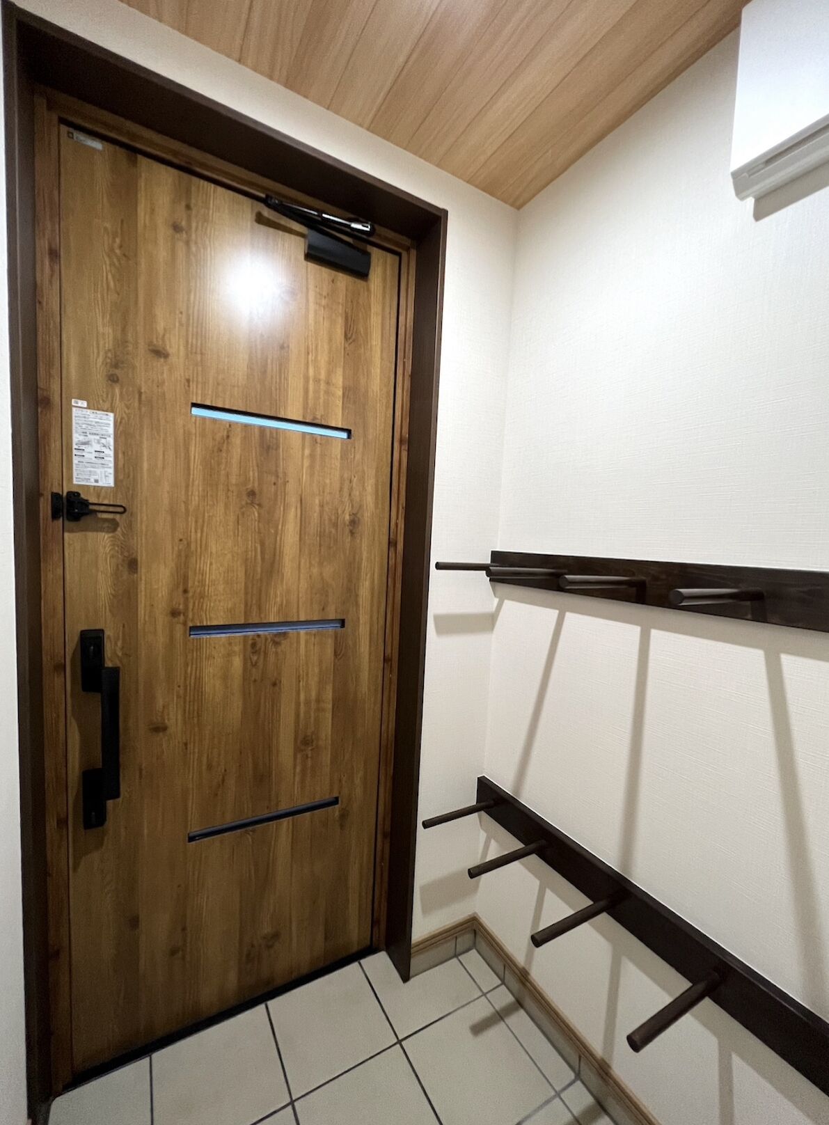 A wooden door with a handle and a small sign on the door.