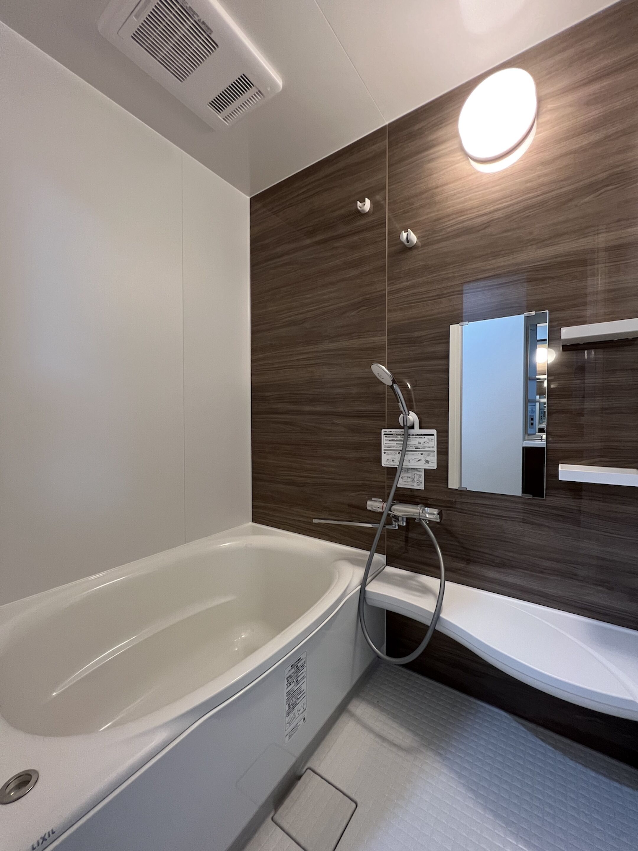A modern bathroom with a freestanding bathtub, a wall-mounted mirror, and a built-in sink.