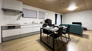 Een moderne keuken met een eethoek, een bank en een televisie.