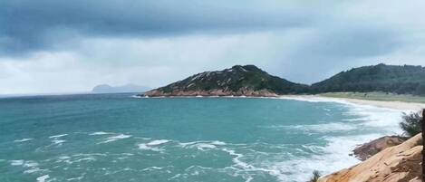 A coastal landscape with rocky terrain and a beach.