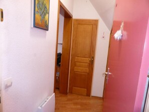 Stylish hallway with a door leading to a space, featuring a painting and a decorative accent.