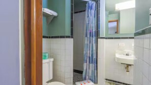 A bathroom with a toilet, shower, and sink. - Travelers Inn by OYO Beaver, Hwy 19 (Beaver)