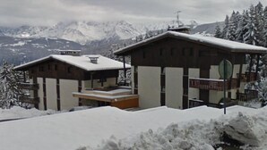Edificio in stile chalet con un balcone e una seggiovia sullo sfondo.
