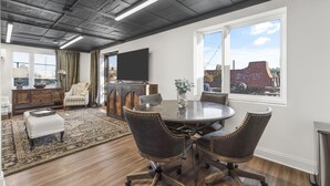 A dining area with a round table, four chairs, a television on the wall, and a view of the outside. - Funky, Fun, and Fabulous!!! (Knoxville)