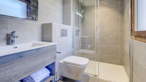 A modern bathroom with a glass-enclosed shower, a white sink, and a toilet. - 140m from ski lifts, 1st floor, terrace, tv, 77m², Morzine (Morzine)