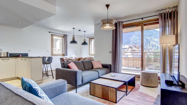 A modern living room with a sofa, coffee table, and a dining area with chairs and a table. - 140m from ski lifts, 1st floor, terrace, tv, 77m², Morzine (Morzine)