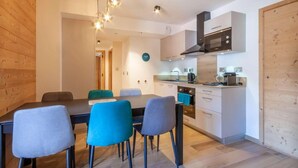 Una cucina moderna con zona pranzo, pareti in legno e un orologio a vista.