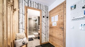 Un baño moderno con cabina de ducha de vidrio, inodoro y lavamanos.
