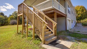 A two-story house with a wooden deck and a covered porch. - Rustic Whitwell Home w/ Grill, Near State Parks! (Whitwell)