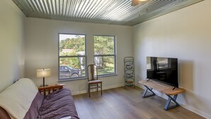 A room with a bed, a TV, a chair, and two windows. - Rustic Whitwell Home w/ Grill, Near State Parks! (Whitwell)