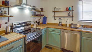 A modern kitchen with stainless steel appliances, wooden countertops, and teal cabinetry. - Rustic Whitwell Home w/ Grill, Near State Parks! (Whitwell)