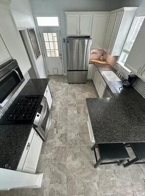 Een microgolfoven, een oven, een kookplaat, een vaatwasser