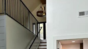 A staircase with wooden steps and a black handrail, leading to a door with a white frame. - Cottage at the Ridge#2-40 min south of Nashville (Spring Hill)
