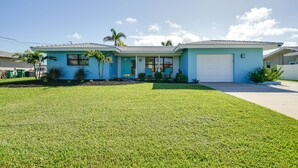 A modern two-story house with a light blue exterior, a garage, and a well-maintained lawn.