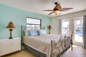 A bedroom with a bed, two nightstands, a ceiling fan, and a window with blinds. - Dock, Grill & Pool: Waterfront Cape Coral Home! (Cape Coral)