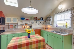 A kitchen with green cabinets, a checkered tablecloth, and a vase of sunflowers. - Charming Livingston Vacation Rental w/ Views! (Livingston)