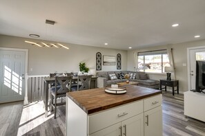 A modern kitchen with a wooden countertop, white cabinetry, and a dining area with a gray table and chairs. - Quiet Pueblo Home w/ Pool Table, 5 Mi to Downtown! (Pueblo)