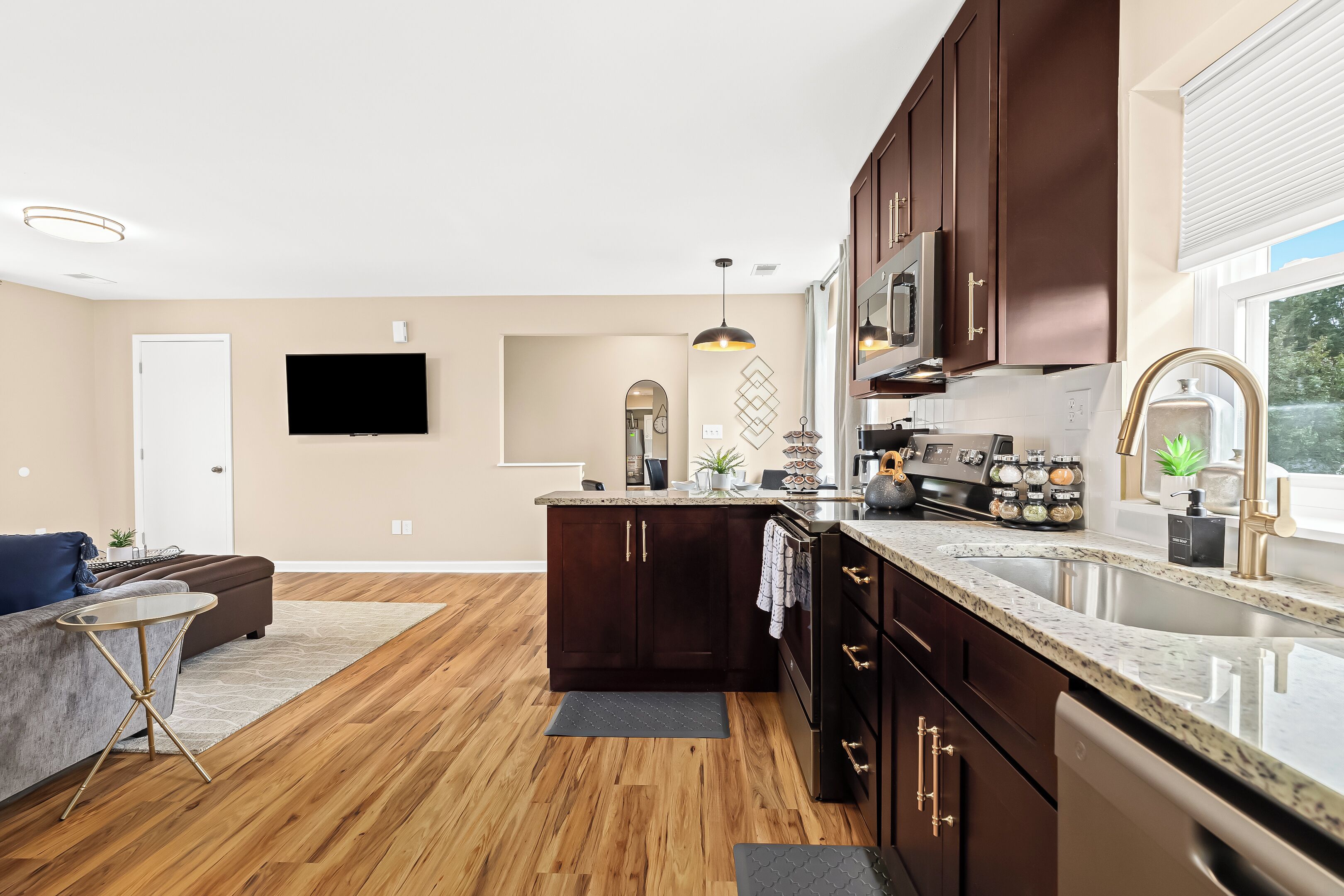 Une cuisine moderne avec des meubles en bois foncé, des appareils électroménagers en acier inoxydable et un grand îlot central.