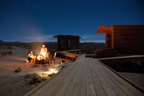 A wooden deck leading to a cabin with a fire pit and seating area. - Secluded Desert House-Stargazing (Ridgecrest)
