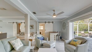 A spacious living area with a ceiling fan, a dining area with a table and chairs, and a view through large windows. - Sarasota Home w/ Pool: 4 Mi to Siesta Key Beach! (Sarasota)