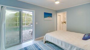 A bedroom with a bed, a sliding glass door to a patio, a ceiling fan, and a painting on the wall. - Sarasota Home w/ Pool: 4 Mi to Siesta Key Beach! (Sarasota)
