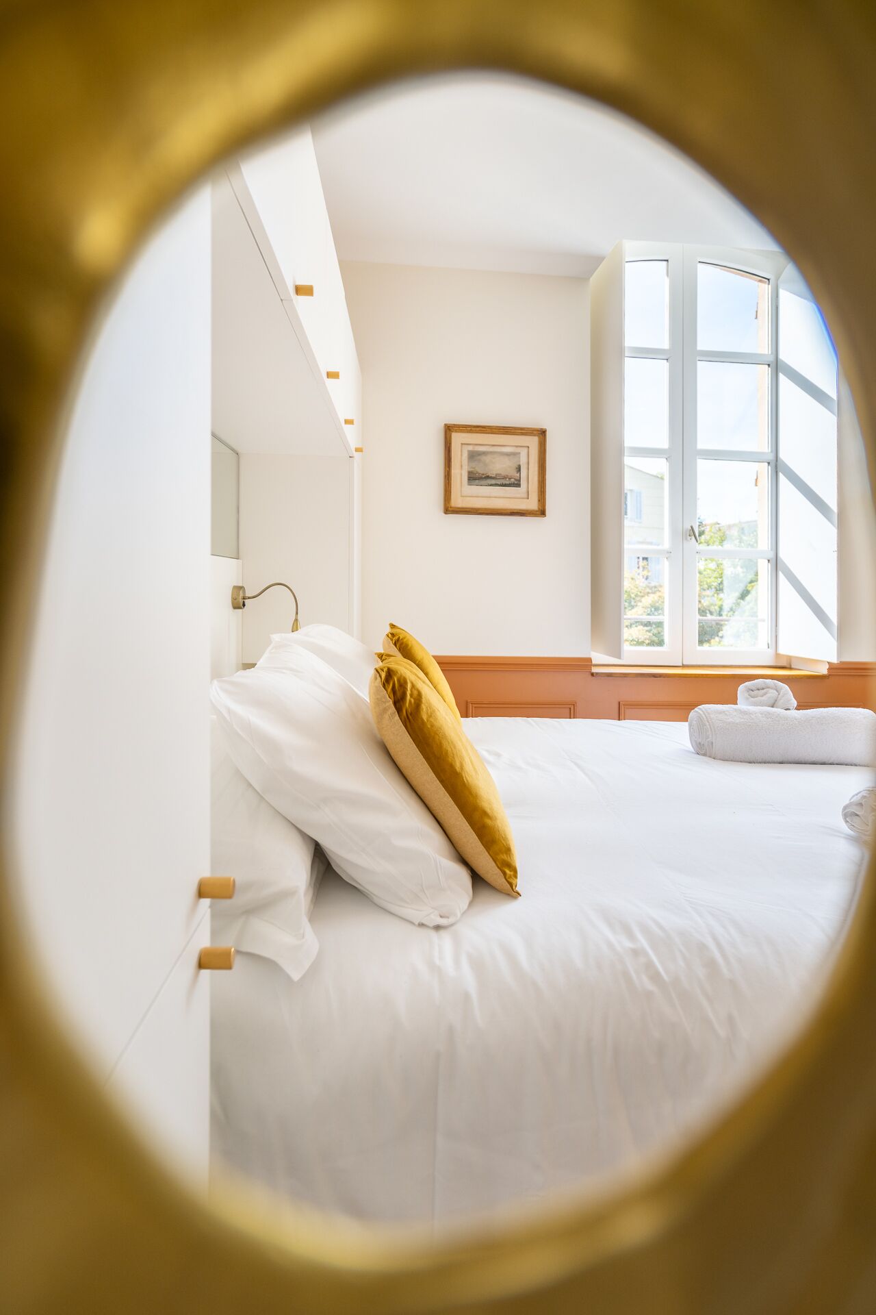 Una habitación de hotel con cama, ventana y un cuadro en la pared.