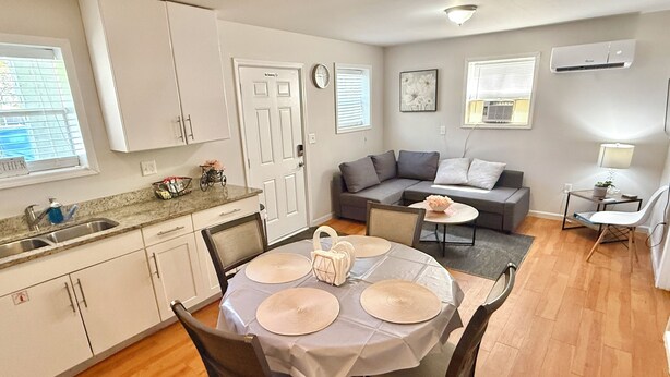 A compact living space with a dining area, kitchenette, and seating area.