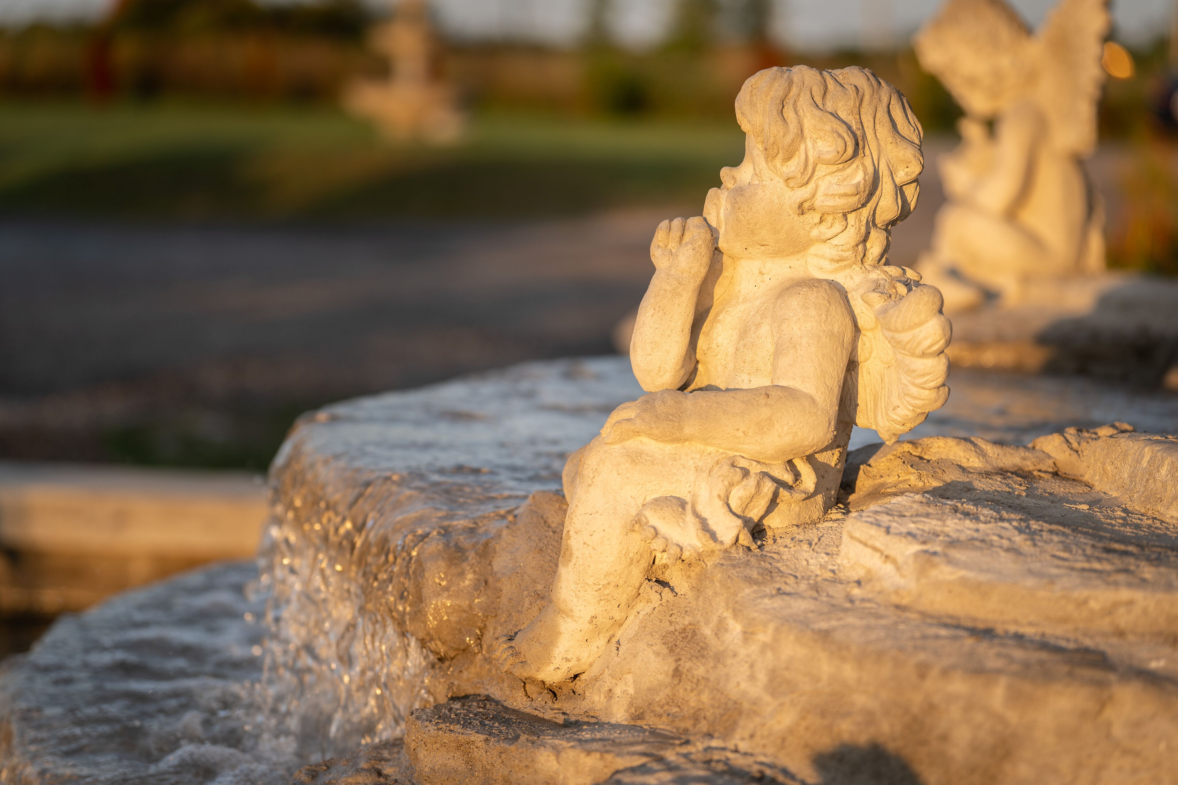 A stone sculpture of a seated figure with a detailed carving.