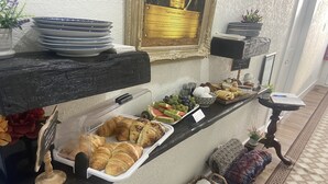 A breakfast buffet with croissants, fruits, and pastries.